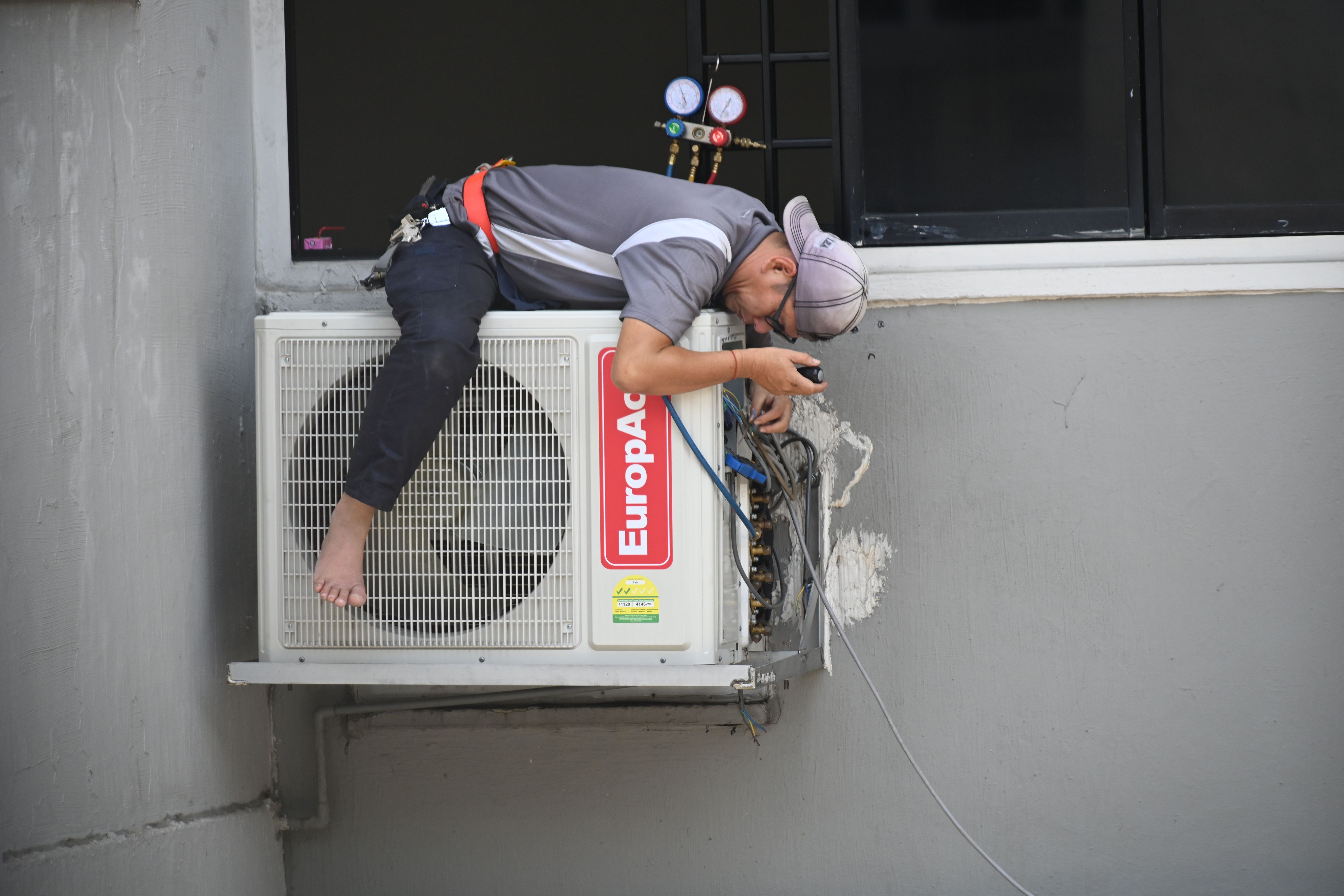 HVAC technician repairing an outdoor air conditioning unit on the job